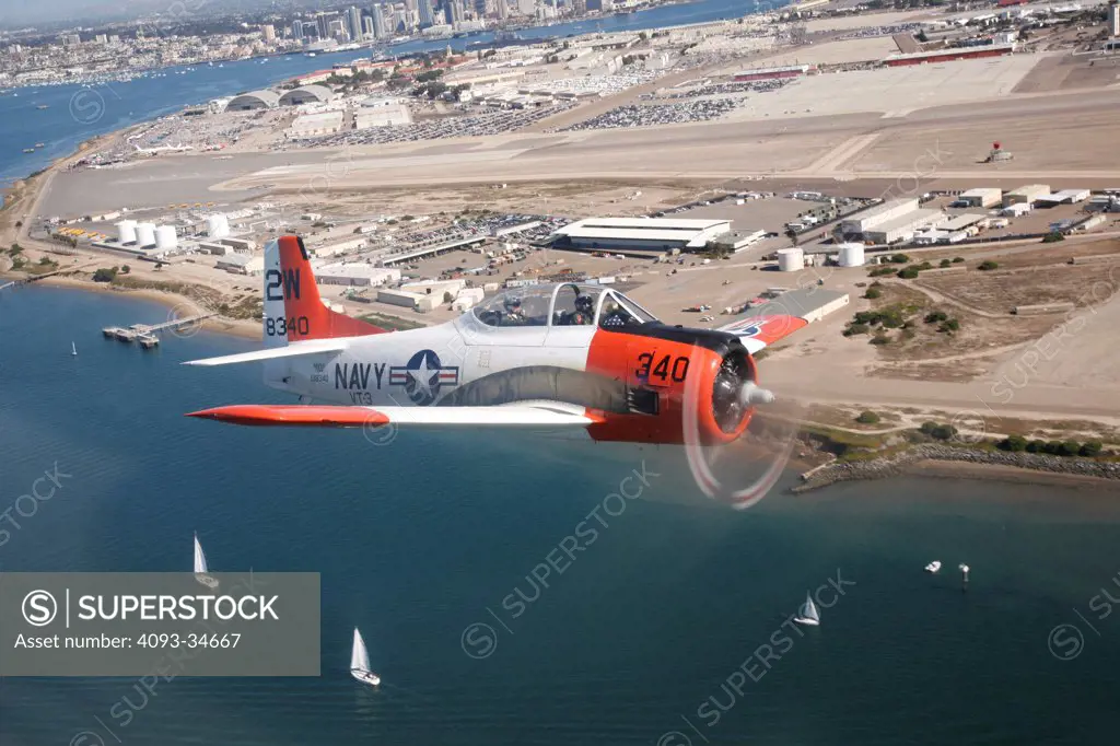 1950 US Navy North American T-28 Trojan military trainer flying over San Diego.