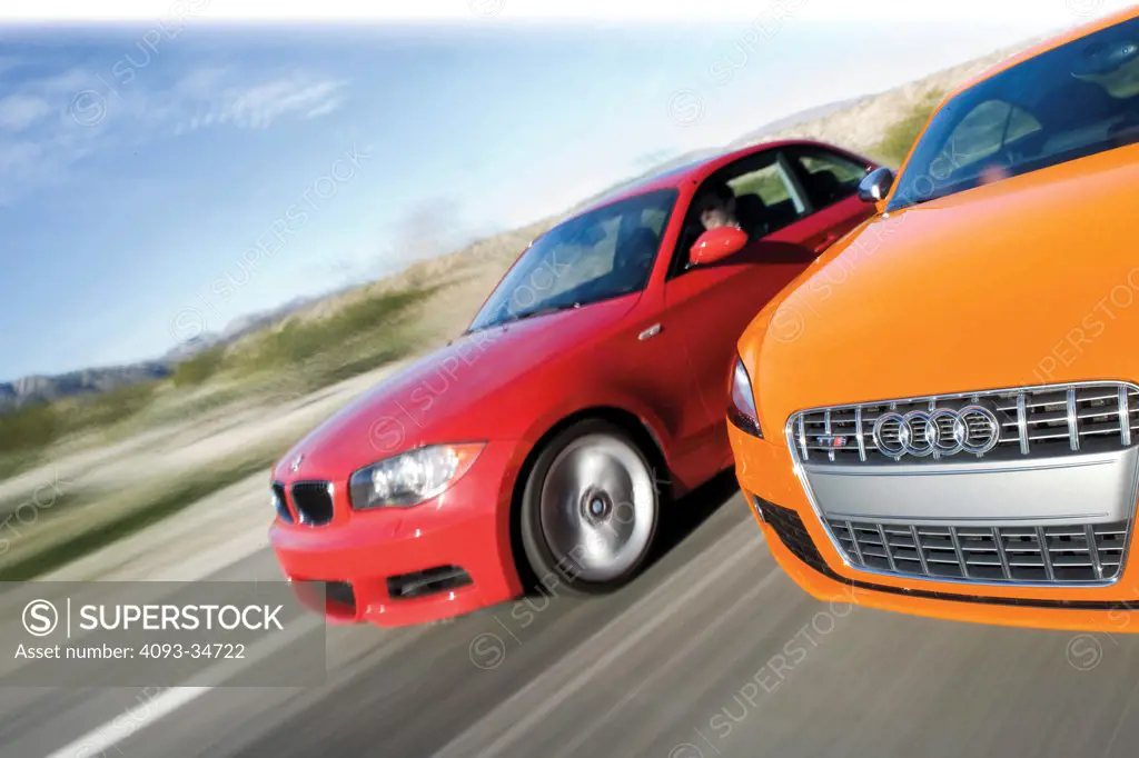 Action view of a 2010 Audi TTS and BMW 135i on a rual road. 