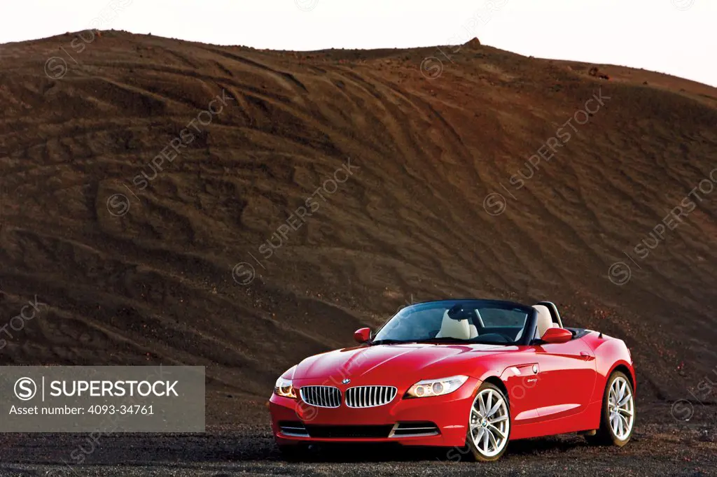 Front 3/4 static view of a 2010 BMW Z4 Roadster parked on a hill of coal.