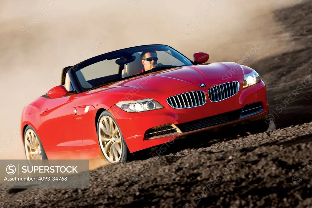 Front 3/4 action view of a 2010 BMW Z4 Roadster driving on a hill of coal.