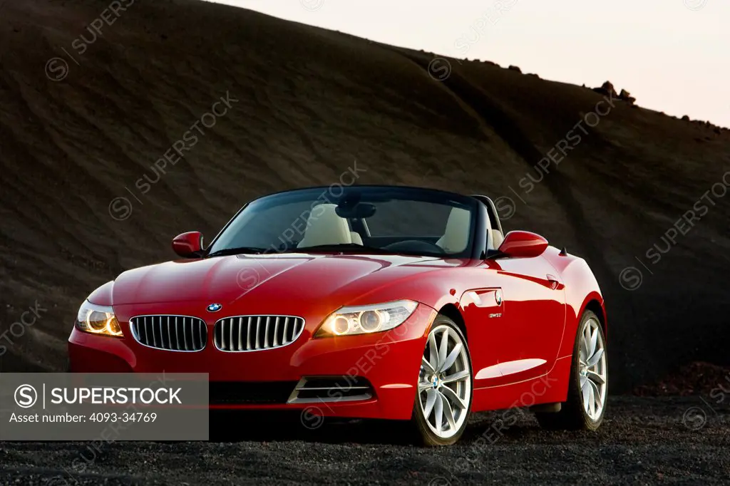 Front 3/4 static view of a 2010 BMW Z4 Roadster parked on a hill of coal.