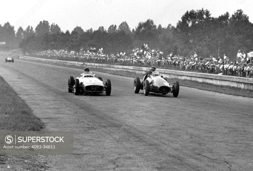 Juan Manuel Fangio (Mercedes-Benz) and Mike Hawthorne (Ferrari) go eyeball to eyeball in the 1954 Italian Grand Prix at Monza.