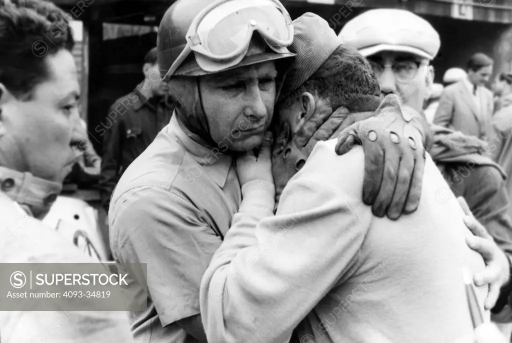 Juan Manuel Fangio (Mercedes-Benz) consoles fellow Argentine Jose Froilan Gonzalez (Ferrari) after the fatal crash of their countryman Onofre Marimon (Maserati) out on the Nurburgring circuit during the 1954 Grand Prix.