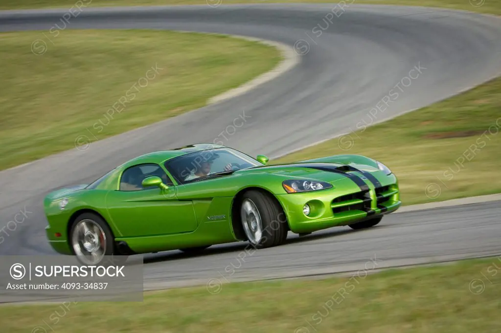 Front 3/4 action view of a green 2010 Dodge Viper SRT10 racing around a track.