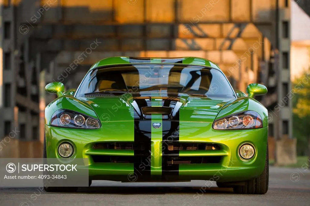Straight on static nose view of a green 2010 Dodge Viper SRT10 underneath a steel elevated railway.