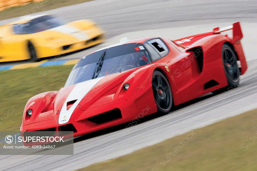 Action view of two Ferrari FXX race cars. This is track day for owners of the Ferrari FXX. Customers pay $2.5 million, but are only allowed to drive the car on special track days which are approved by Ferrari.