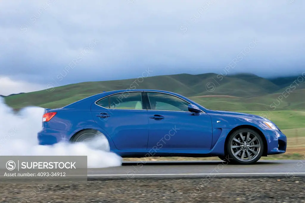 Profile action view of a blue 2010 Lexus IS-F doing a burnout.