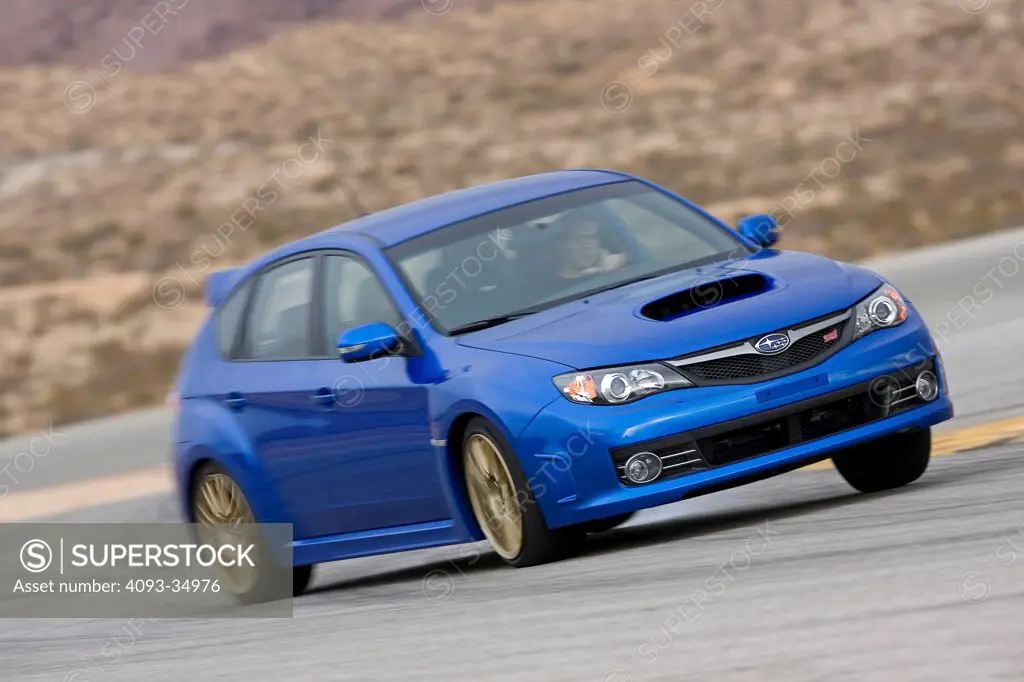 Front 3/4 action view of a blue 2008 Subaru WRX STI on a race desert race track.