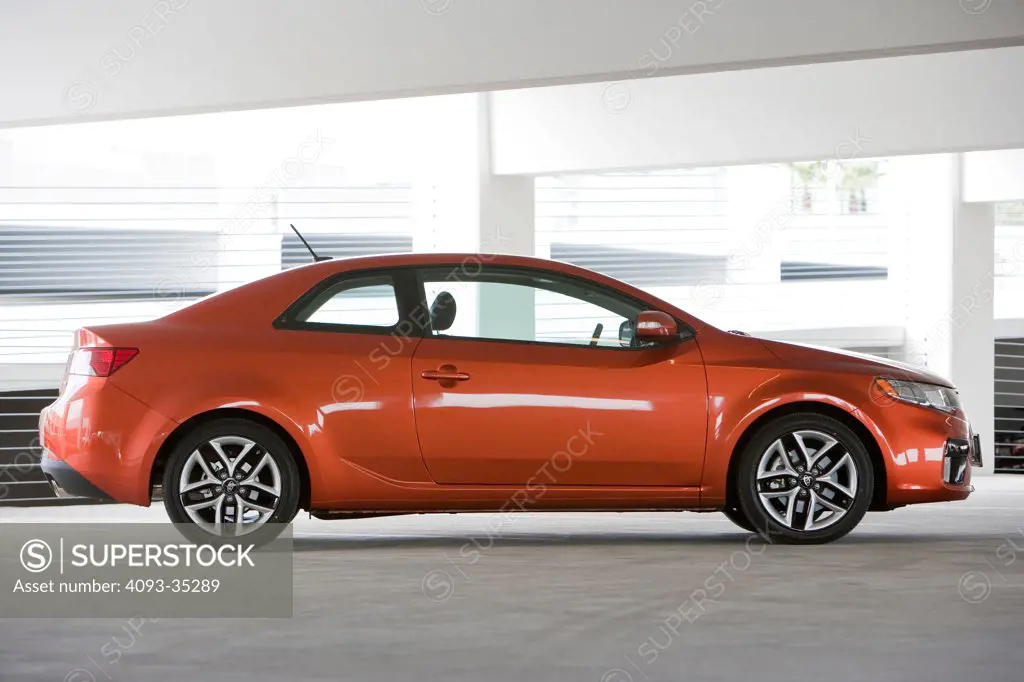 2010 Kia Forte Koup coupe parked in a parking structure, profile static view