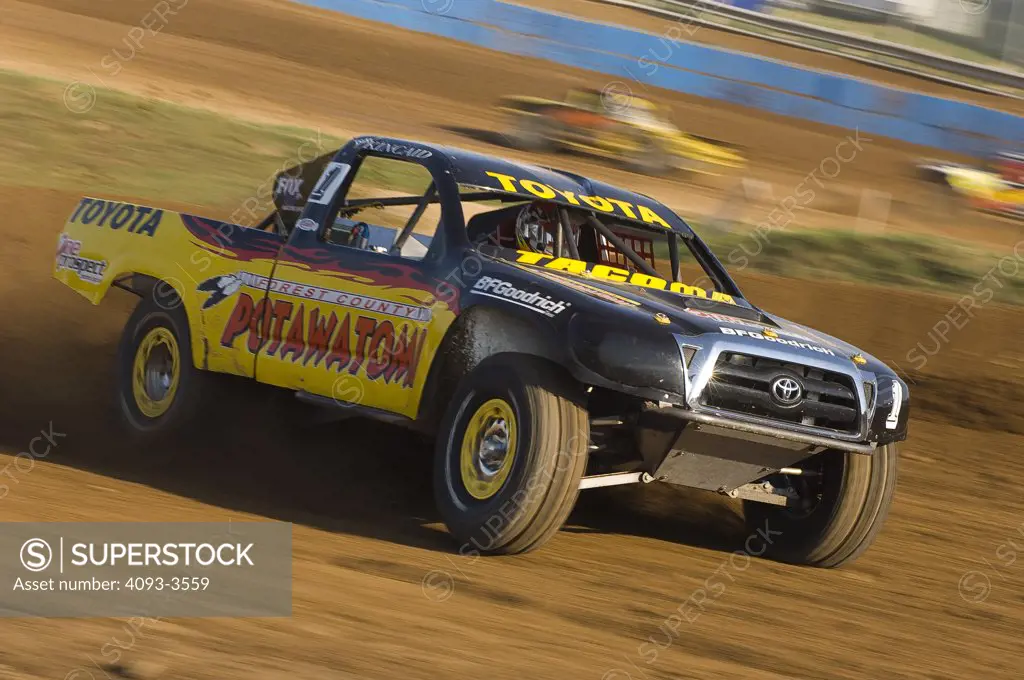 baja desert racing truck in action during a race.  kicking up dust and dirt
