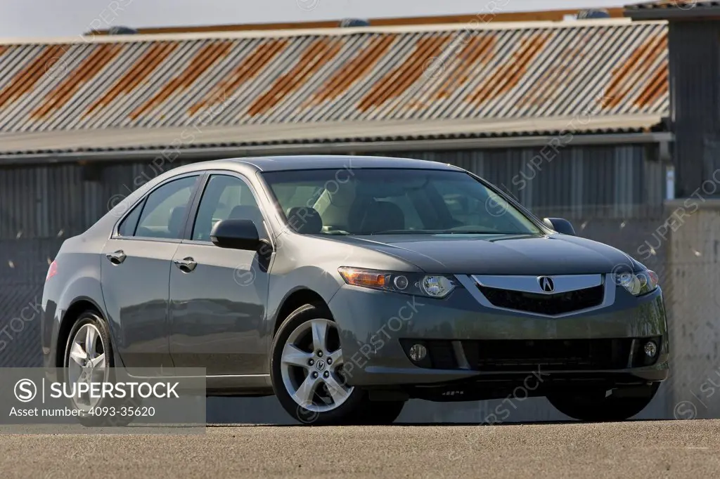 2009 Acura TSX parked in front of a corrugated metal building, front 3/4