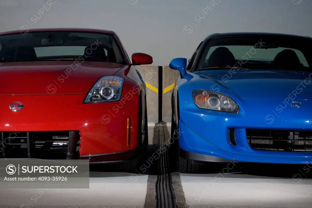 2008 Honda S2000 and red 2007 Nissan Nismo 350Z parked in a parking structure, front view