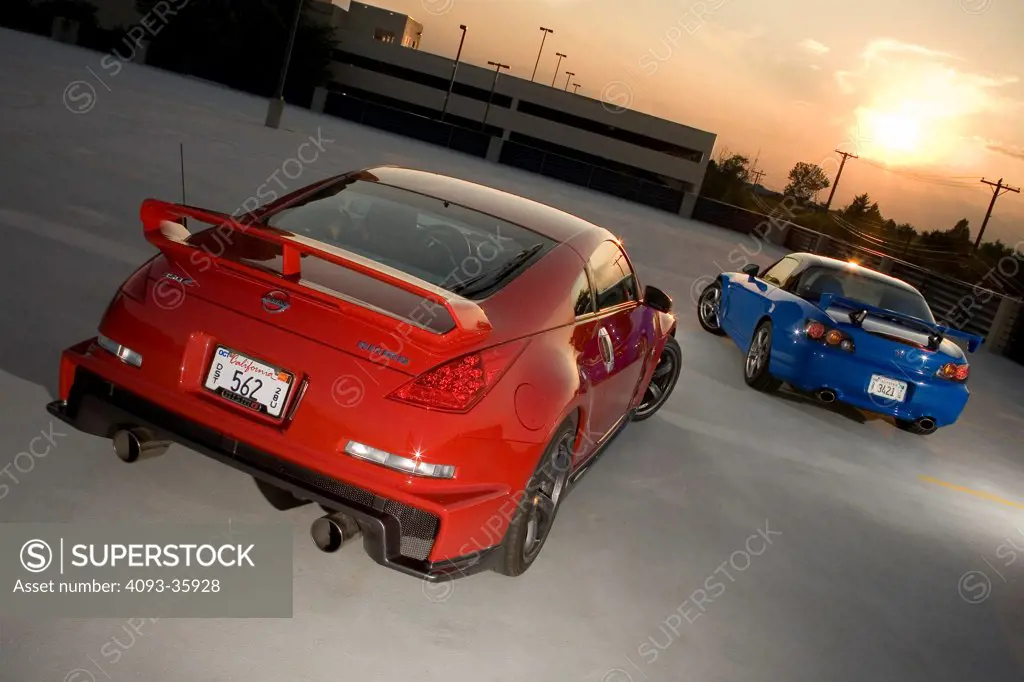 2008 Honda S2000 and red 2007 Nissan Nismo 350Z parked in a parking structure, rear 3/4