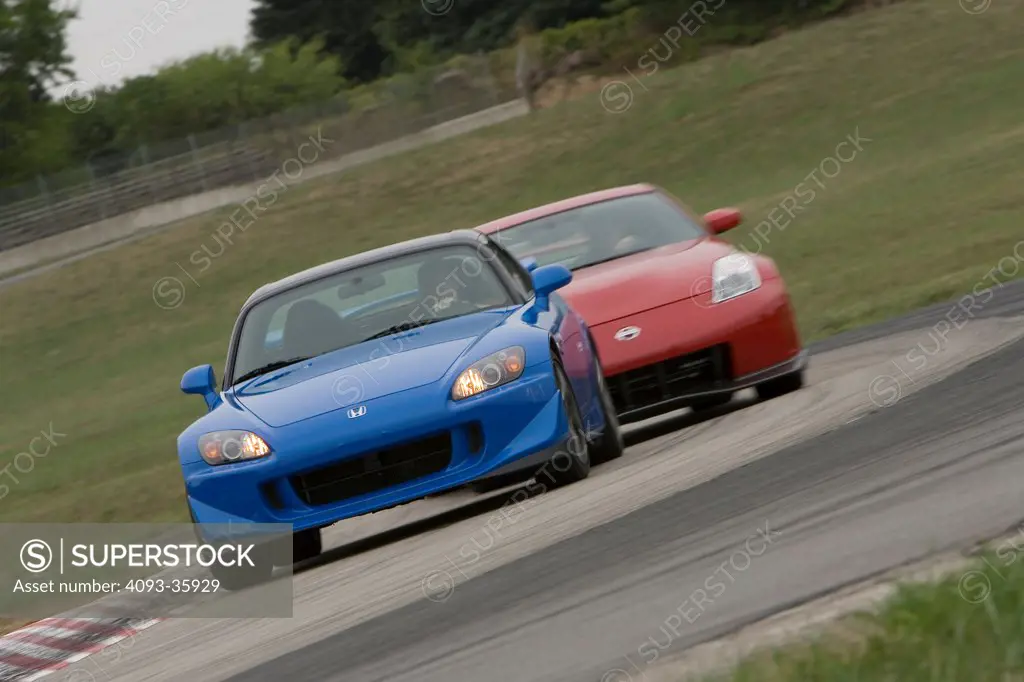 2008 Honda S2000 and red 2007 Nissan Nismo 350Z racing on a race track, front view