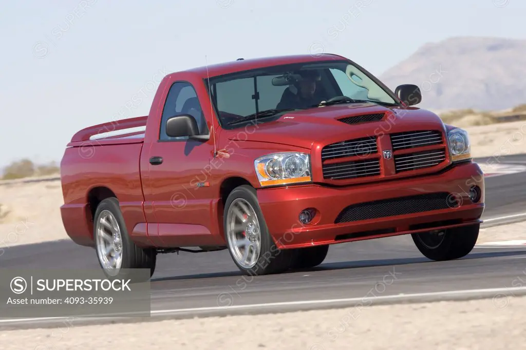 2006 Dodge Ram SRT10 truck racing on a race track, front 3/4