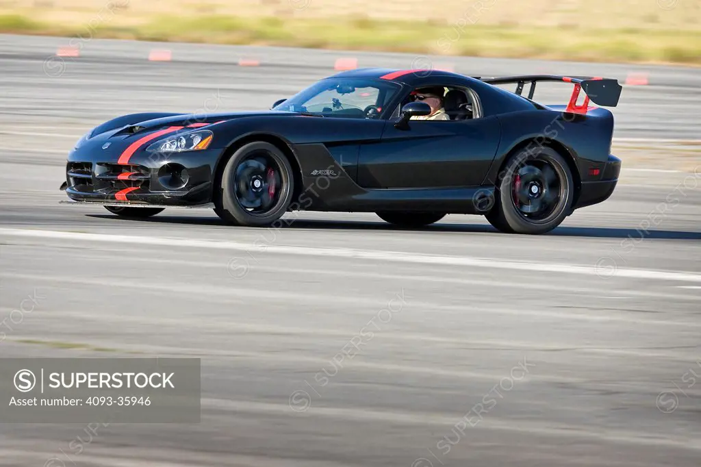 Profile panning action view of a black 2009 Dodge Viper ACR racing on a race track