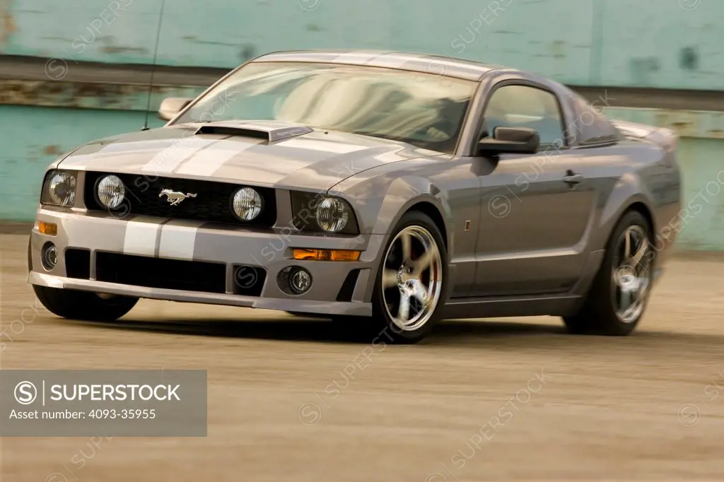 2006 Ford Roush Mustang driving on urban road, front 3/4