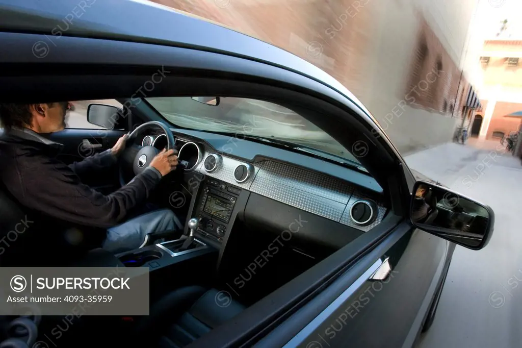2008 Ford Mustang Bullitt driving down a narrow alley
