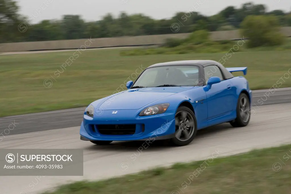 2008 Honda S2000 in a four wheel drift on a race track, front 3/4