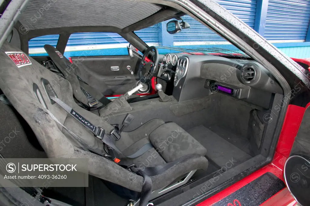 2006 Noble M400 showing the bucket racing seats, steering wheel, instrument panel, center console, gear shift lever, dashboard and parking brake