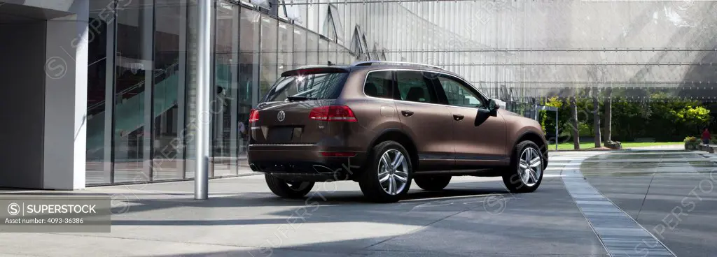 Rear 3/4 static view of a brown 2011 Volkswagen Touareg parked on an urban street.