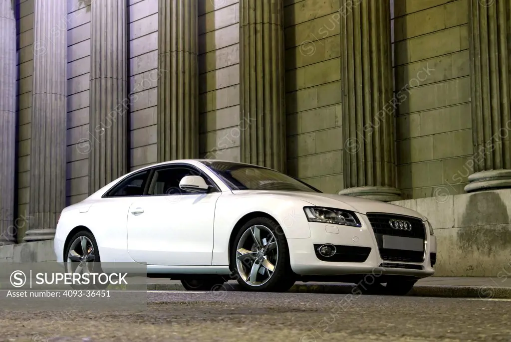 2010 Audi A5 parked by city building at night, front 3/4