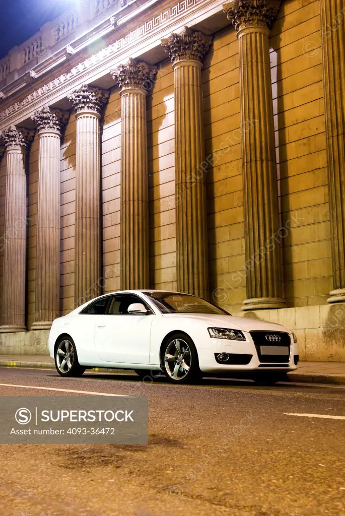 2010 Audi A5 parked by city building at night, front 3/4