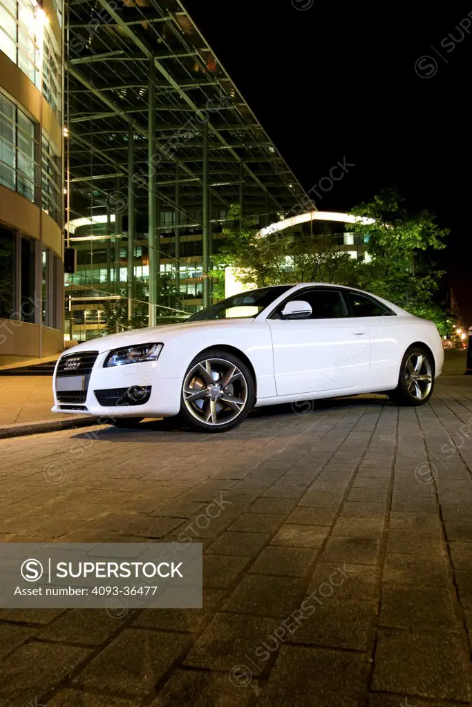 2010 Audi A5 parked in city at night, front 3/4