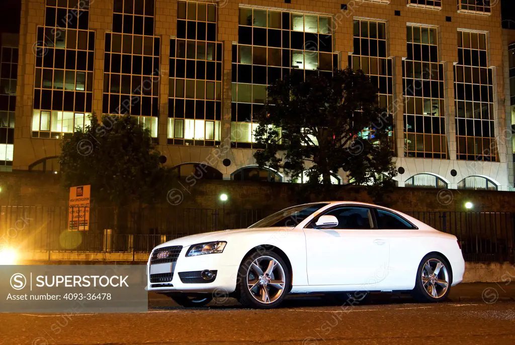 2010 Audi A5 parked in city at night, front 3/4