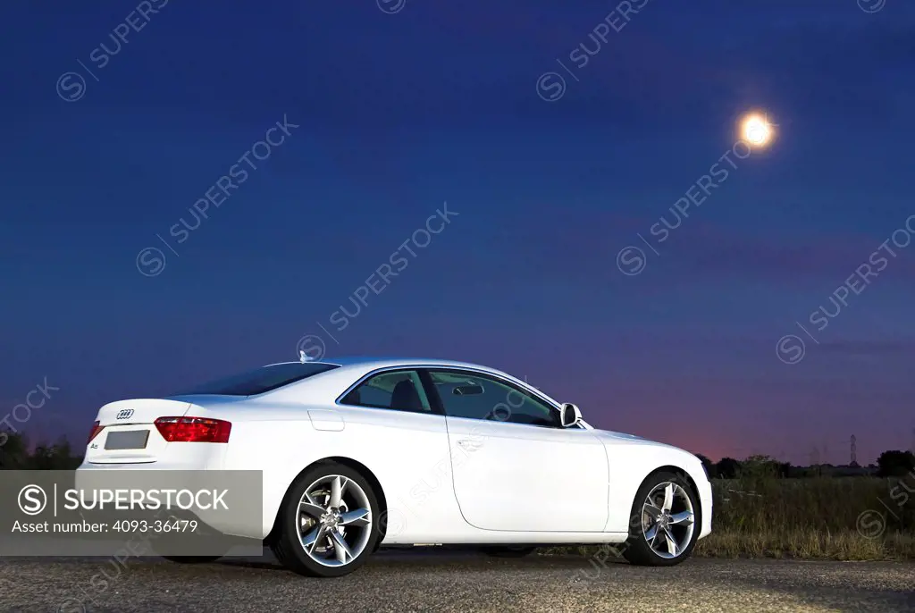2010 Audi A5 parked in city at night, rear 3/4