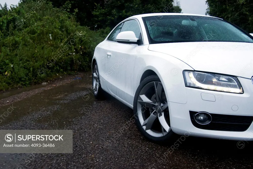 2010 Audi A5 parked on waterlogged rural road, front 3/4 close-up