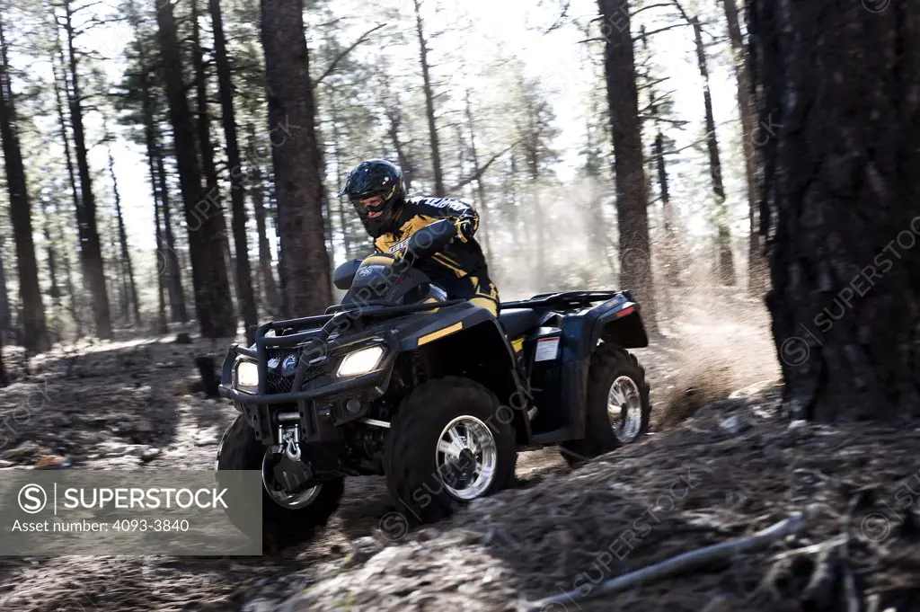 Can-Am ATV riding through forest terrain