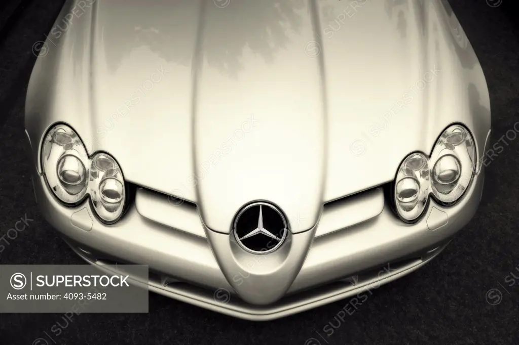 front nose of a benz logo badge on the grill with headlights