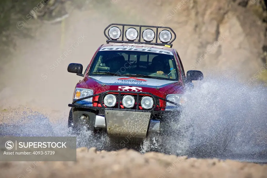 Baja Race Truck off road racer racing mud and dirt flying Offroad racing through water splashing