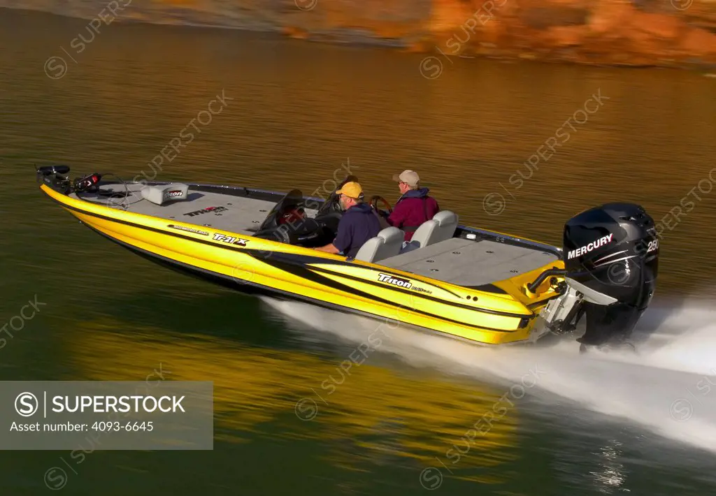 high angle bass boat yellow outboard motor wake spray - SuperStock