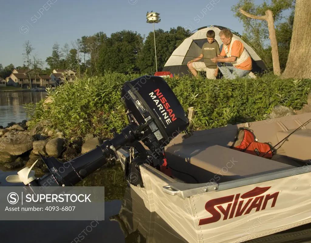 Grandfather teaching grandson how to fly fish while camping on Sylvan Lake, Indiana Nissan 6 Four stroke engine on Sylvan aluminum boat Winston Luzier