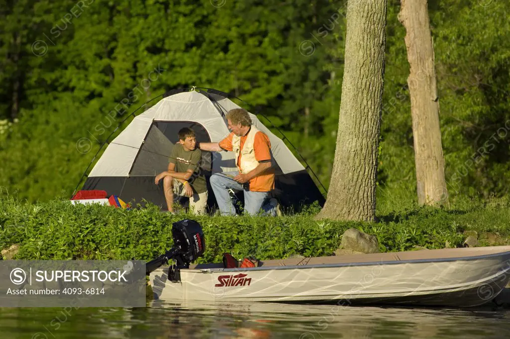 Grandfather teaching grandson how to fly fish while camping on Sylvan Lake, Indiana Nissan 6 Four stroke engine on Sylvan aluminum boat Winston Luzier