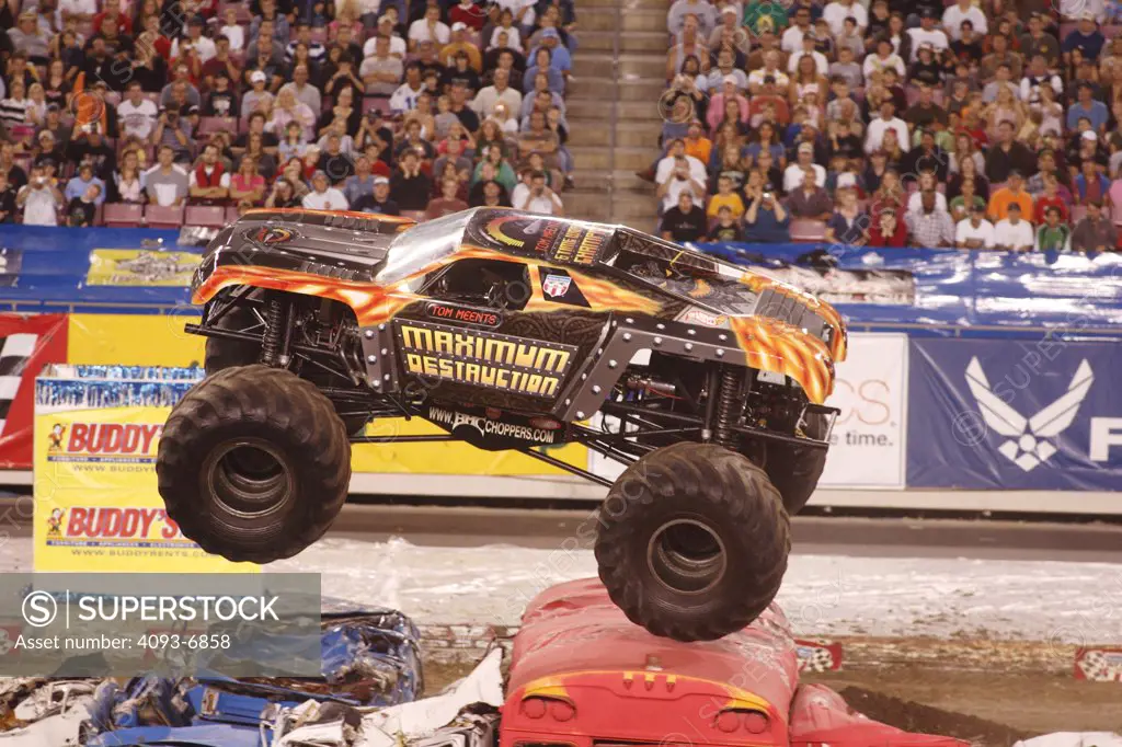 Maximum Destruction Monster Truck jumping buses at a Monster Truck Rally in Raymond James Stadium, Tampa, FL. A monster truck is an automobile, typically a pickup truck, which has been modified or purposely built with extremely large wheels and suspension. Typically, a monster truck show involves the truck crushing smaller vehicles beneath its huge tires. These trucks can run up and over most man-made barriers, so they are equipped with remote shut-off switches, called the Remote Ignition Interu