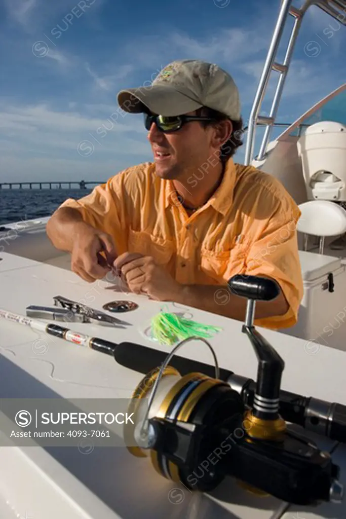 Fisherman rigging line with artificial lures on the rear / stern of a Trophy 2502 Walkaround boat.