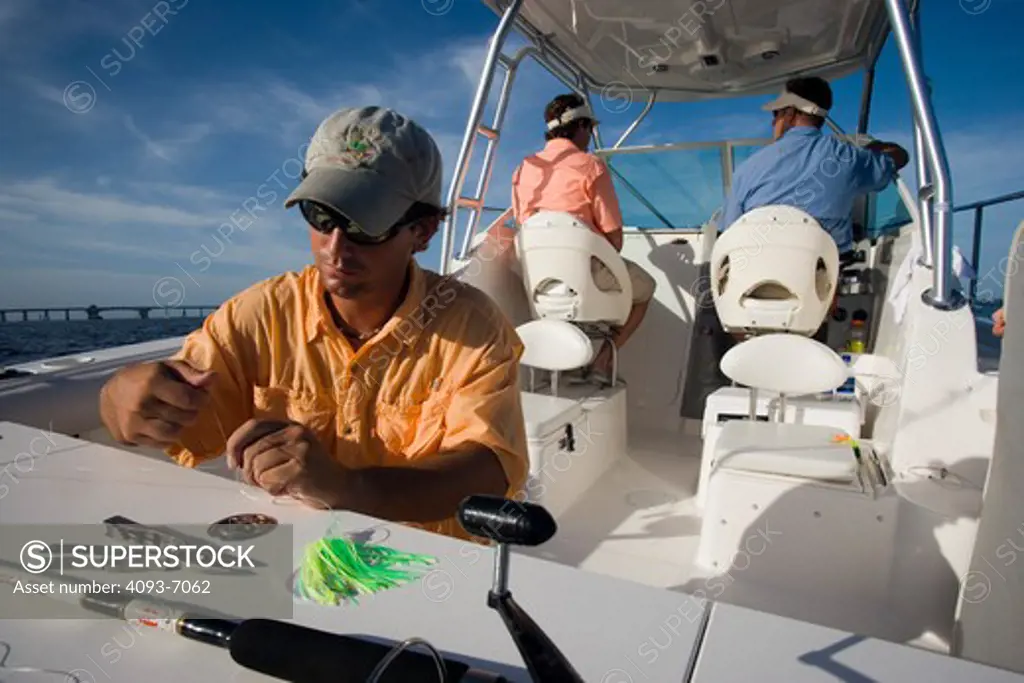 Fisherman rigging line with artificial lures on the rear / stern of a Trophy 2502 Walkaround boat.