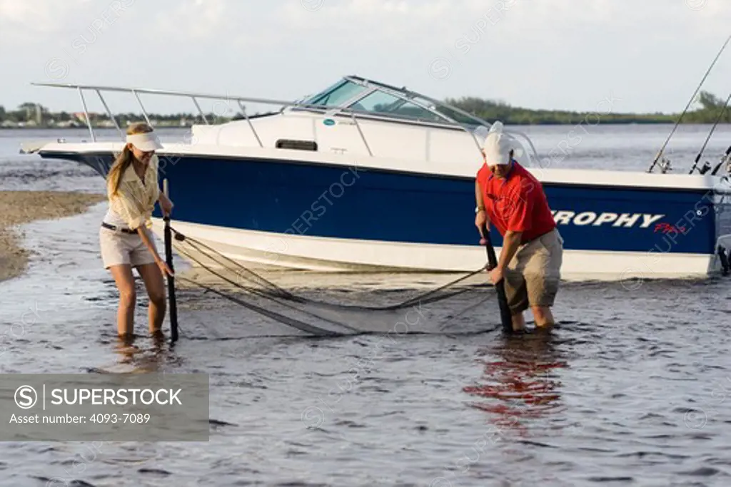 Couple seine netting along shore near Fort Myers, Florida. Trophy 2052 Walkaround boat.