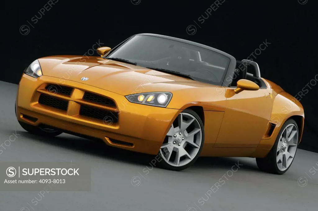 Front 3/4 view of a Dodge Demon Convertible concept. Gold color inside parked viewing with backdrop