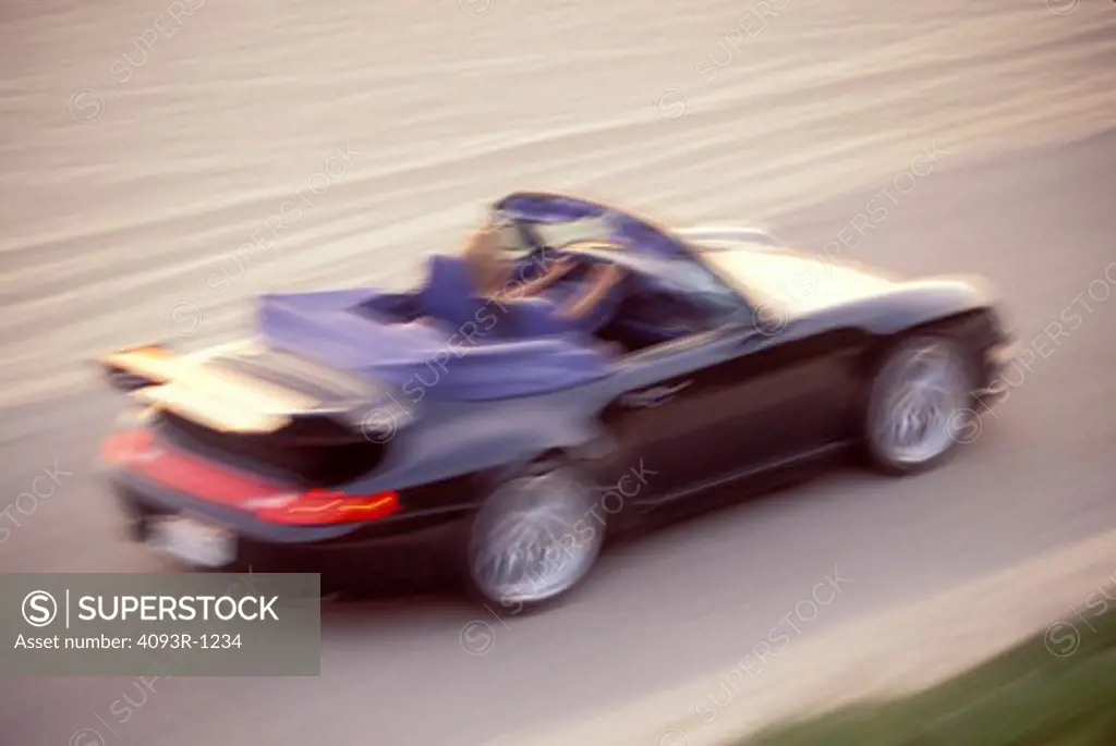 Porsche 1998 911 Carrera Cabriolet black rear 3/4 blur woman asphalt pavement sand beach dunes 1990s street