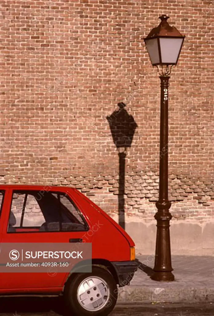 hatchback red rear end street lamp light brick wall Madrid Spain city