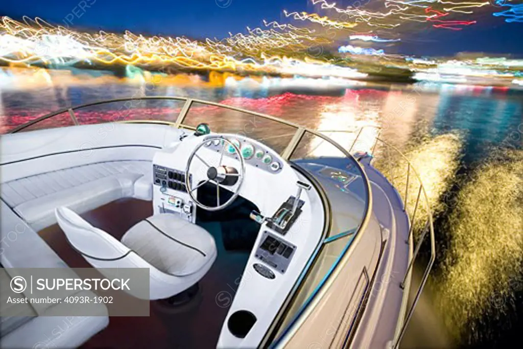 2005 Bayliner Discovery 288 driving at night with the interior of the boat in focus and the water and lights blurry