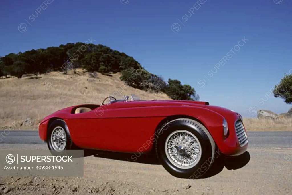1951 Ferrari 166 MM Barchetta beauty front 3/4 profile Lusso touring race car. The 166 MM Touring Barchetta, a Ferrari masterpiece, still increase pulse rates fifty-five years later. It is the first Ferrari sports car; all previous cars were strictly for racing. Craftsmen welded a tubular frame with a 2,200 mm wheelbase to hand-formed body panels. Beneath the hood resides a Colombo designed 1,995 cc 60-degree V-12. The 166 MM was arguably the world's fastest sports car in its day. In the heyday,