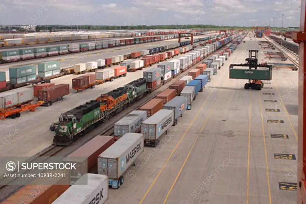 Cargo containers being loaded / unloaded from trucks to railroad cars at Logistics Park Chicago. BNSF Cargo container freight yard in Joliet,  Illinois.