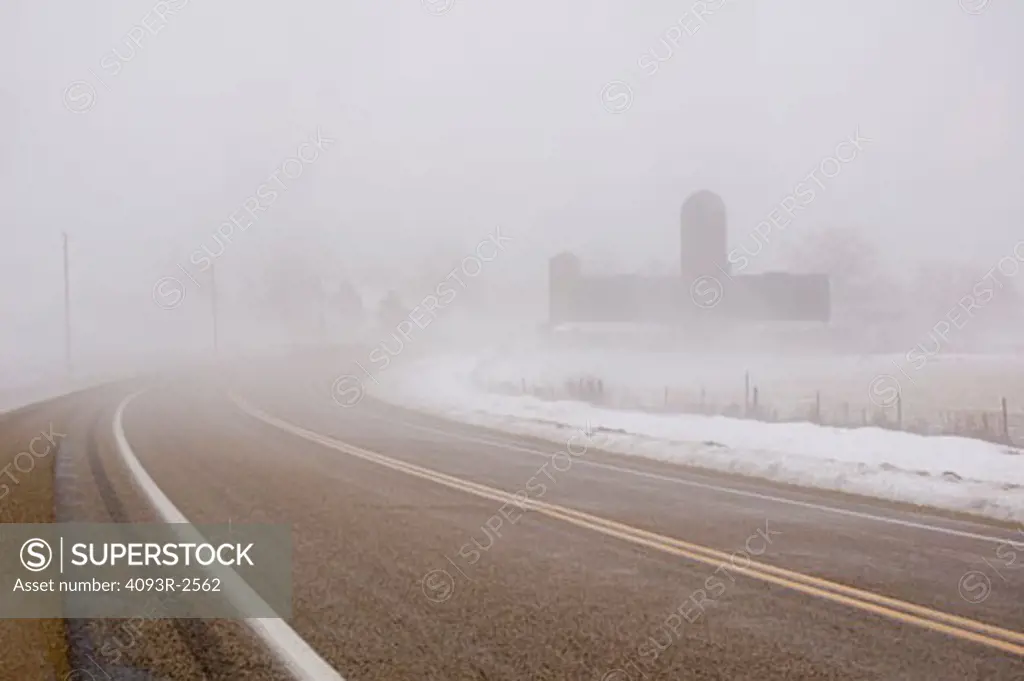 Highway 92 past barn in winter fog, southwest Wisconsin