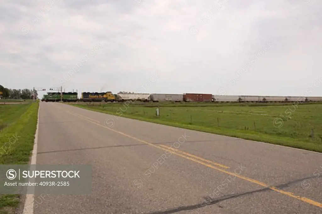 Rural 2-lane road and train at crossing, northeast Iowa