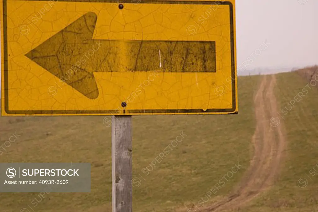 Turn arrow sign and rural dirt road,  northeastern Iowa